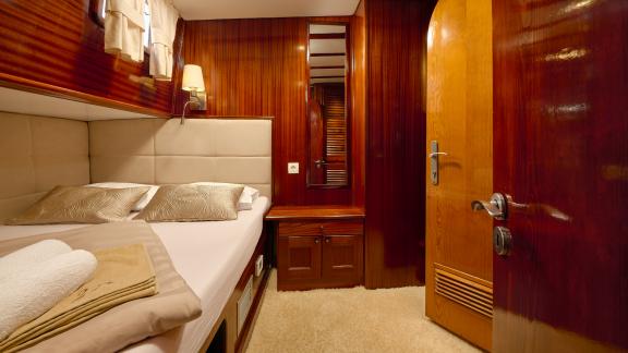 A cosy cabin on the Gulet Linda with a double bed and elegant wooden walls.